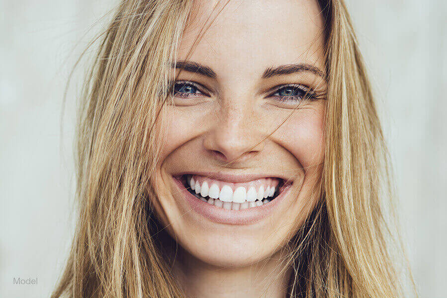 Close up headshot of a young adult woman smiling