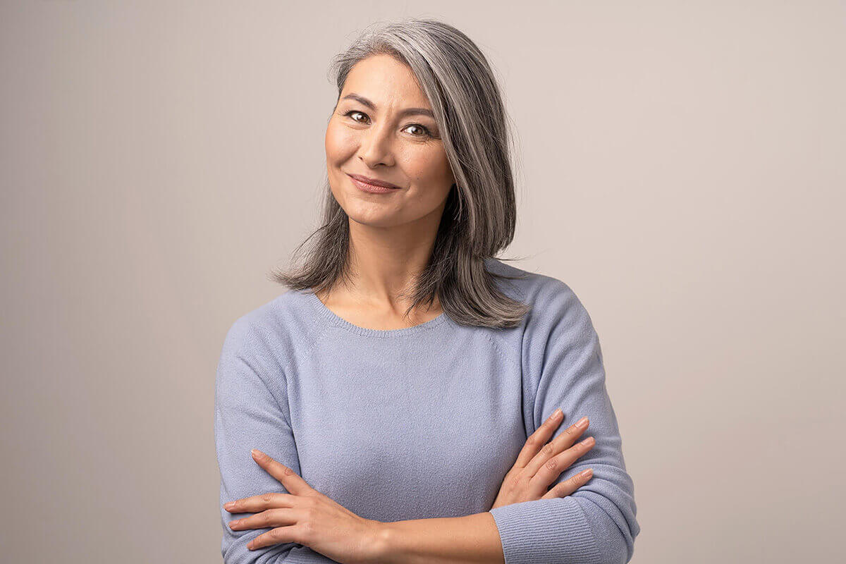 Middle aged woman smiling with her arms crossed